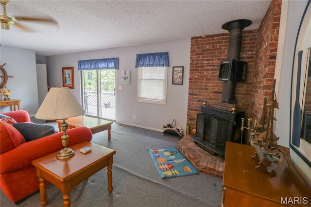 1207 Napoleon Dr, Bonne Terre, MO 63628 - living area featuring a wood stove, carpet flooring, a textured ceiling, and a ceiling fan