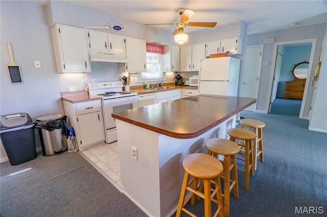 1207 Napoleon Dr, Bonne Terre, MO 63628 - kitchen featuring white appliances, under cabinet range hood, white cabinetry, ceiling fan, and light colored carpet