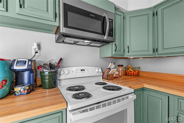 kitchen with white range with electric cooktop, stainless steel microwave, butcher block counters, and green cabinetry