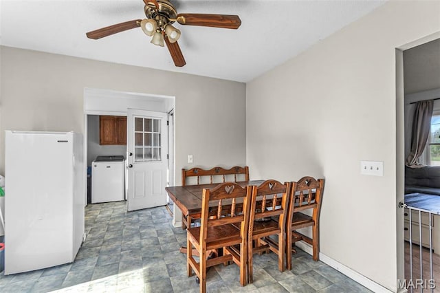 dining area featuring a ceiling fan, washer / clothes dryer, and baseboards