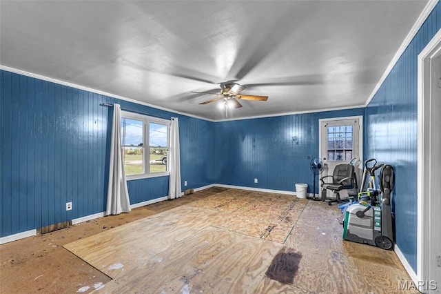 empty room featuring ornamental molding, a ceiling fan, and baseboards