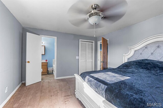 bedroom featuring light carpet, baseboards, ensuite bathroom, and a closet