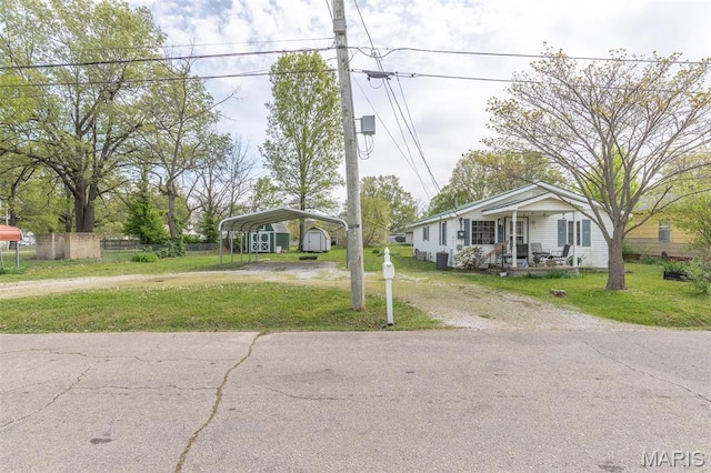 712 Nickey St, Poplar Bluff, MO 63901 - view of front facade featuring driveway, a detached carport, and a porch