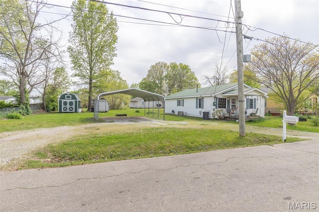 712 Nickey St, Poplar Bluff, MO 63901 - view of front of property featuring a shed, dirt driveway, a detached carport, an outbuilding, and a front yard