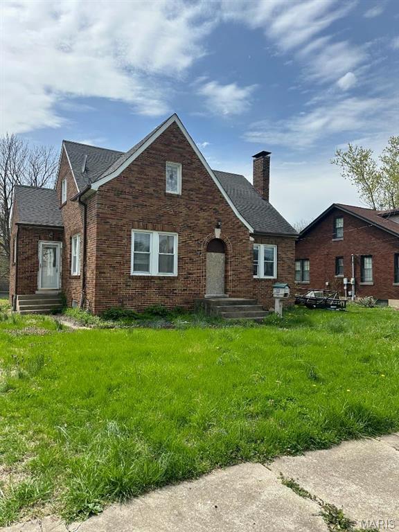713 S Rapp Ave, Columbia, IL 62236 - tudor home featuring a chimney, brick siding, and a shingled roof