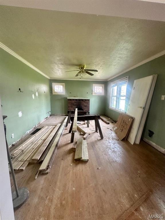 713 S Rapp Ave, Columbia, IL 62236 - misc room with ornamental molding, a ceiling fan, a brick fireplace, wood finished floors, and baseboards