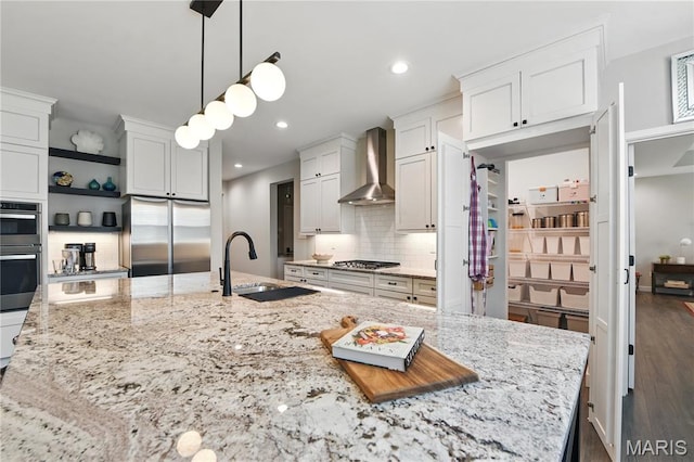 2202 Dartmouth Gate Cir, Wildwood, MO 63011 - kitchen with appliances with stainless steel finishes, wall chimney exhaust hood, a sink, backsplash, and white cabinetry
