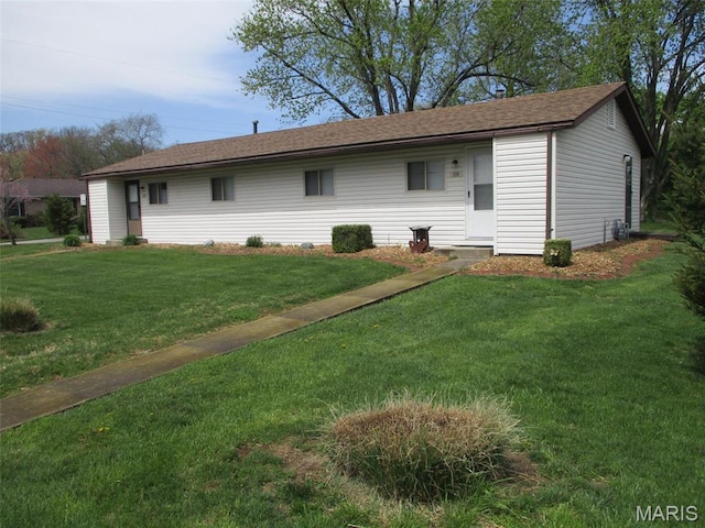 rear view of property with a yard and roof with shingles