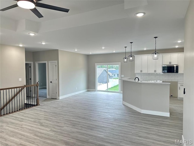 208 Pacific Ave, Union, MO 63084 - kitchen with stainless steel microwave, light wood-type flooring, baseboards, backsplash, and recessed lighting