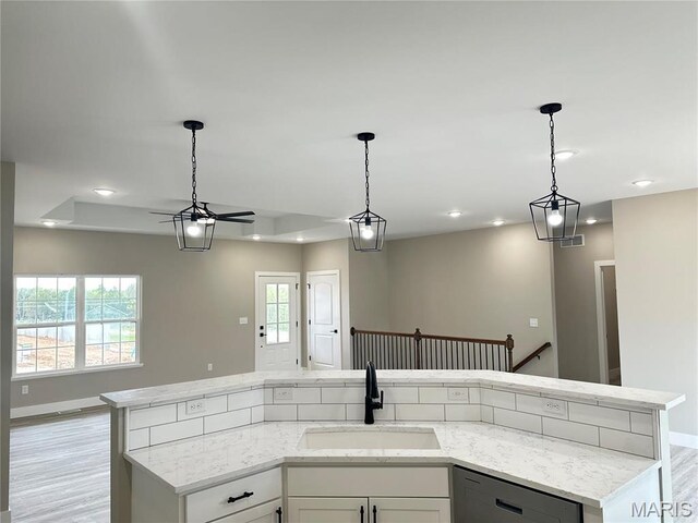 208 Pacific Ave, Union, MO 63084 - kitchen featuring a sink, open floor plan, dishwasher, light stone countertops, and pendant lighting
