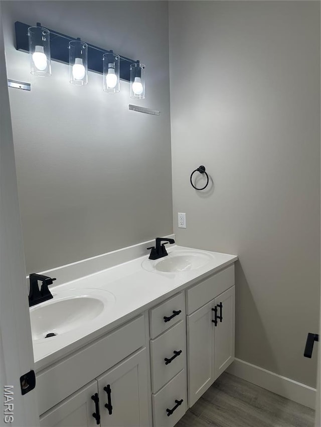 208 Pacific Ave, Union, MO 63084 - bathroom featuring wood finished floors, double vanity, and baseboards