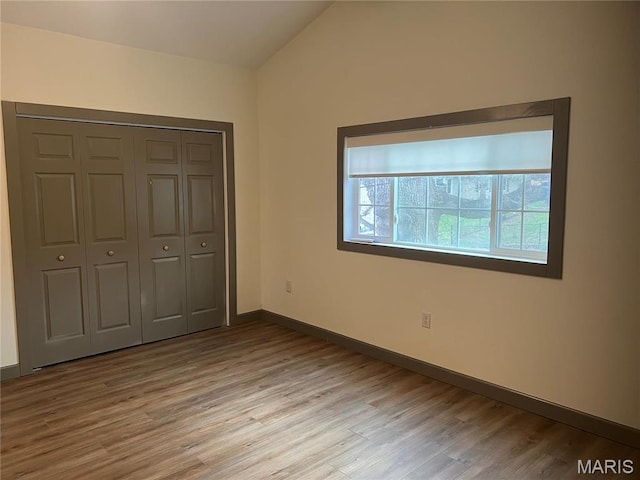 1512 36th St, Hannibal, MO 63401 - unfurnished bedroom featuring light wood finished floors, vaulted ceiling, a closet, and baseboards