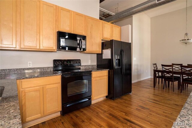1520 Washington Ave Unit 604, Saint Louis, MO 63103 - kitchen with black appliances, light brown cabinetry, dark wood-style flooring, and dark stone counters