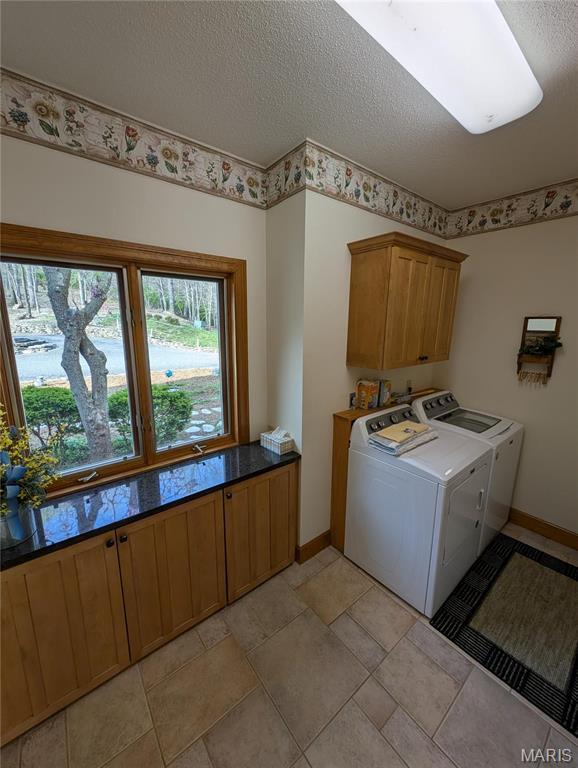 1 River Ridge Rd, Grafton, IL 62037 - clothes washing area with cabinet space, washing machine and clothes dryer, a textured ceiling, and baseboards