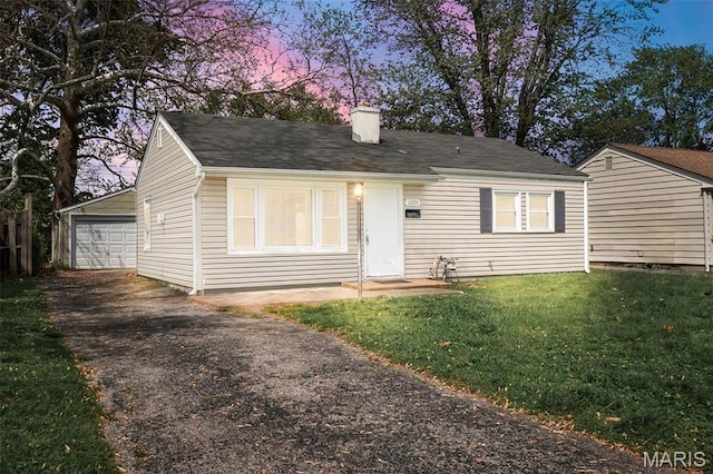 11225 Saint Shawn Ln, Saint Ann, MO 63074 - view of front of home featuring asphalt driveway, a chimney, a front yard, a detached garage, and an outdoor structure