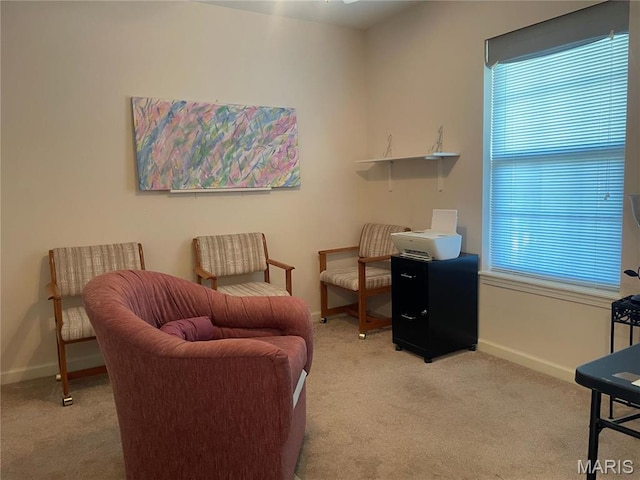 sitting room featuring light carpet and baseboards