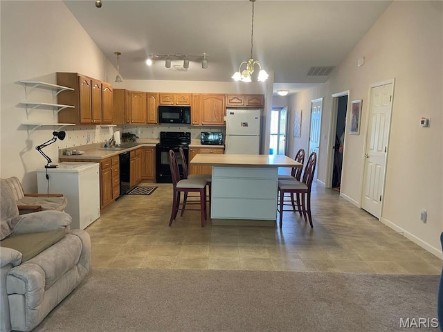 kitchen featuring black appliances, open shelves, a chandelier, a kitchen breakfast bar, and a kitchen island