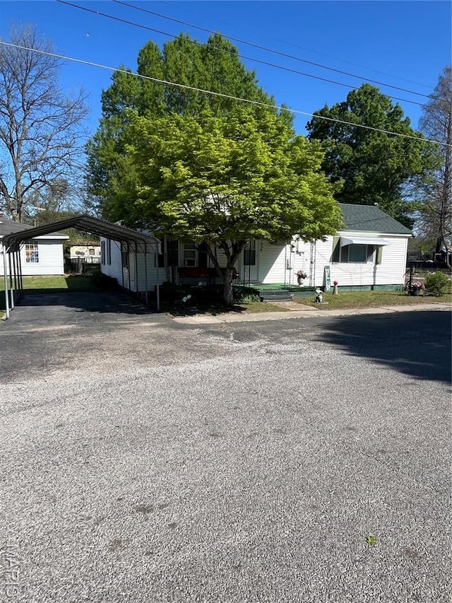 316 Bellvue St, Steele, MO 63877 - view of property hidden behind natural elements featuring a detached carport and asphalt driveway