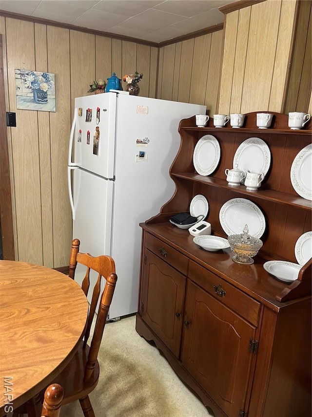 316 Bellvue St, Steele, MO 63877 - kitchen with dark countertops, freestanding refrigerator, light colored carpet, and wooden walls