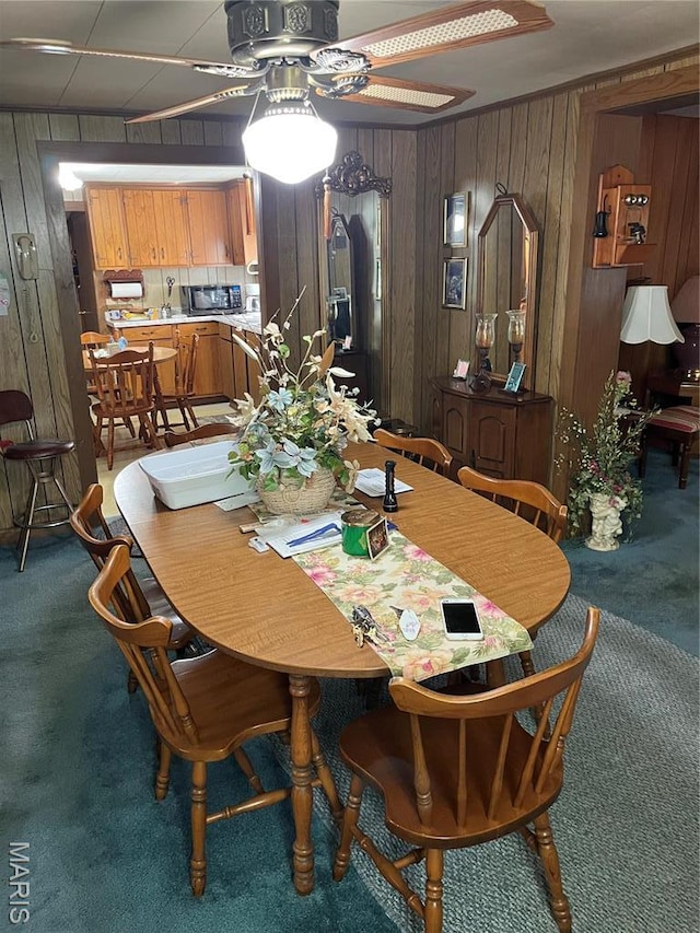 316 Bellvue St, Steele, MO 63877 - dining space with carpet floors, wood walls, and a ceiling fan