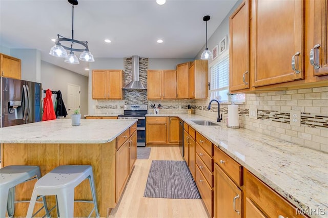 1024 Brook Mont Dr, Ofallon, MO 63366 - kitchen featuring wall chimney exhaust hood, stainless steel appliances, a sink, light wood-style flooring, and a kitchen island