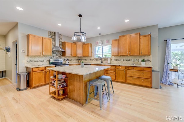 1024 Brook Mont Dr, Ofallon, MO 63366 - kitchen with stainless steel electric stove, wall chimney range hood, light wood-type flooring, a sink, and recessed lighting