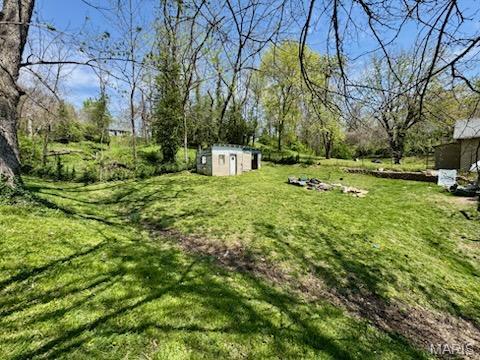 1018 Hayward St, Hannibal, MO 63401 - view of grassy yard featuring a storage shed and an outbuilding
