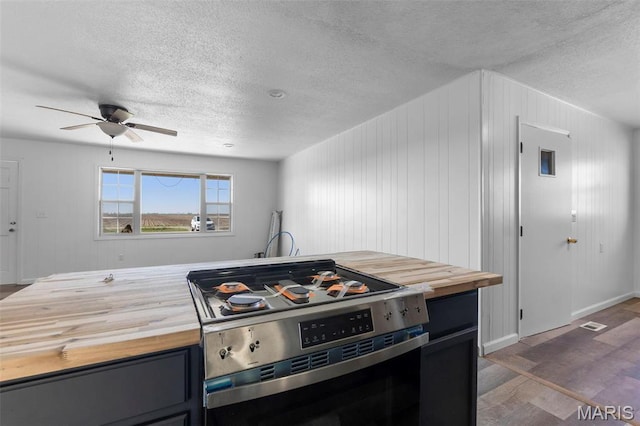 2112 County Highway 264, Gideon, MO 63848 - kitchen with butcher block countertops, stainless steel range with gas cooktop, ceiling fan, a textured ceiling, and wood finished floors