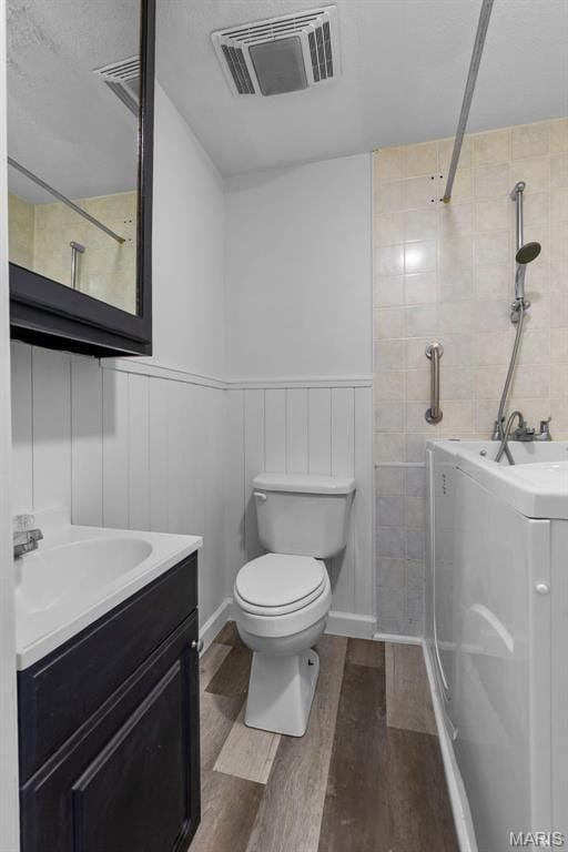 2112 County Highway 264, Gideon, MO 63848 - full bathroom with washer / dryer, wood finished floors, vanity, toilet, and a tile shower