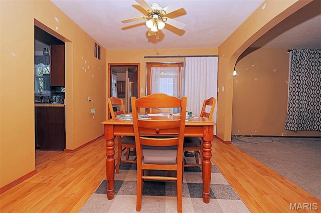 304 Reuter St, Park Hills, MO 63601 - dining space with arched walkways, light wood finished floors, ceiling fan, and baseboards