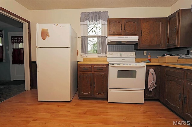 304 Reuter St, Park Hills, MO 63601 - kitchen featuring white appliances, under cabinet range hood, dark brown cabinetry, and light countertops