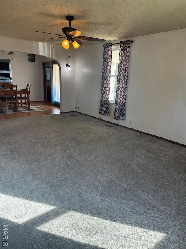 304 Reuter St, Park Hills, MO 63601 - unfurnished living room with carpet, ceiling fan, a textured ceiling, and arched walkways
