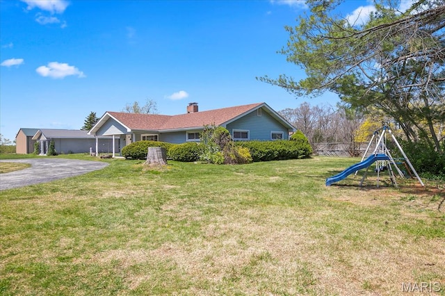 view of property exterior featuring a chimney, a playground, and a lawn