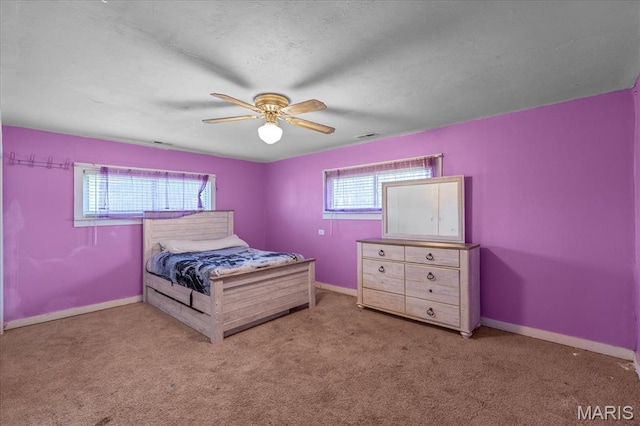 carpeted bedroom with multiple windows, baseboards, and ceiling fan