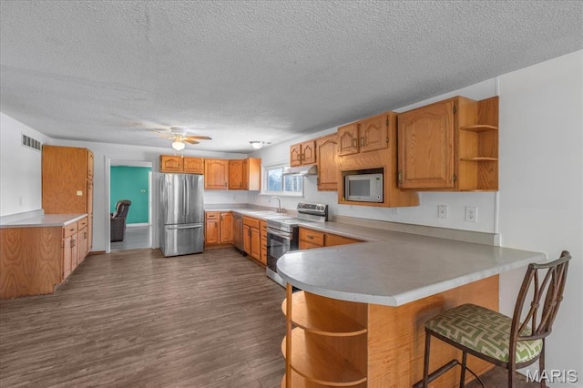 kitchen with open shelves, appliances with stainless steel finishes, a sink, a peninsula, and a textured ceiling