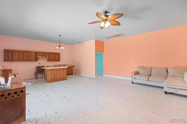 living area featuring baseboards, a chandelier, and a ceiling fan