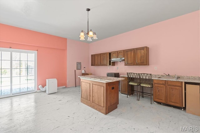 kitchen with brown cabinets, a chandelier, a sink, pendant lighting, and concrete flooring