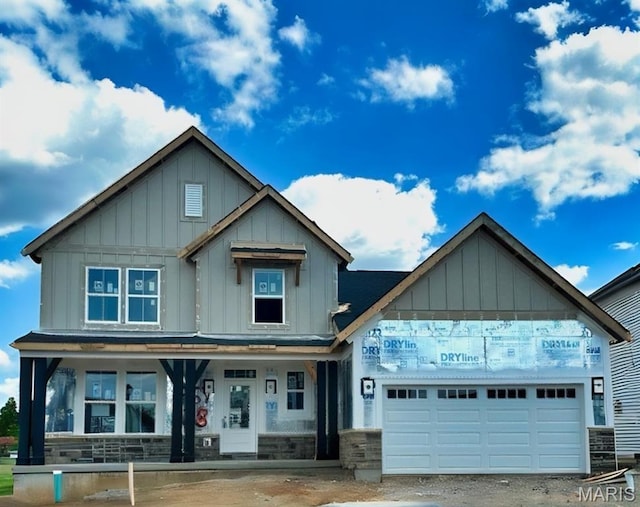 6726 Snowy Owl Ln, Affton, MO 63123 - view of front facade with board and batten siding, a porch, a garage, and stone siding