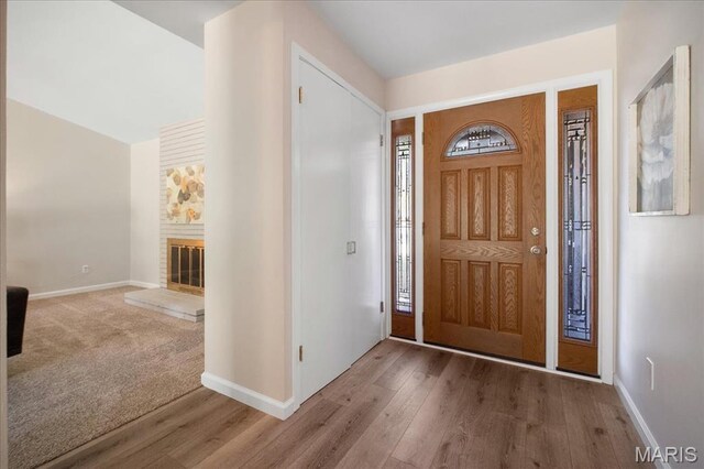 3105 Newgate Dr, Florissant, MO 63033 - foyer entrance featuring wood finished floors, baseboards, and a fireplace