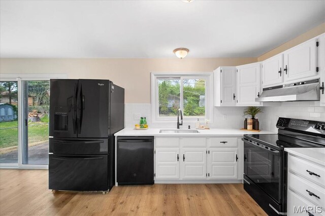 3105 Newgate Dr, Florissant, MO 63033 - kitchen with black appliances, a sink, under cabinet range hood, and healthy amount of natural light