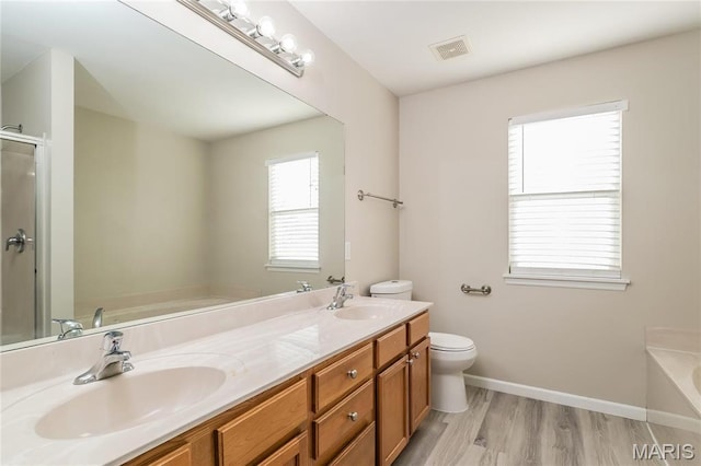 4007 Lafayette Ave, Saint Louis, MO 63110 - full bathroom with toilet, a tub to relax in, double vanity, wood finished floors, and baseboards