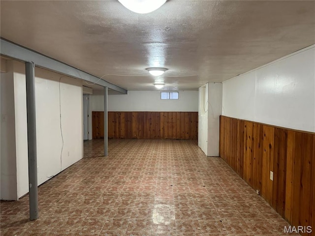1731 Atmore Dr, Saint Louis, MO 63136 - basement with wood walls, a textured ceiling, and a wainscoted wall