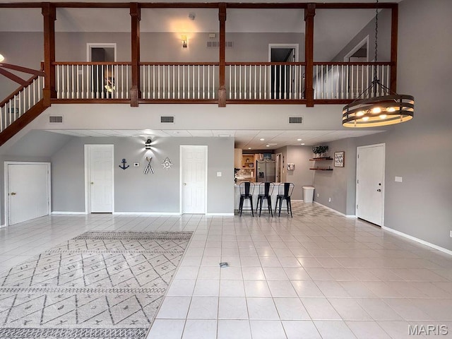 632 N Lafitte Dr, Bonne Terre, MO 63628 - unfurnished living room with a towering ceiling, light tile patterned flooring, and baseboards