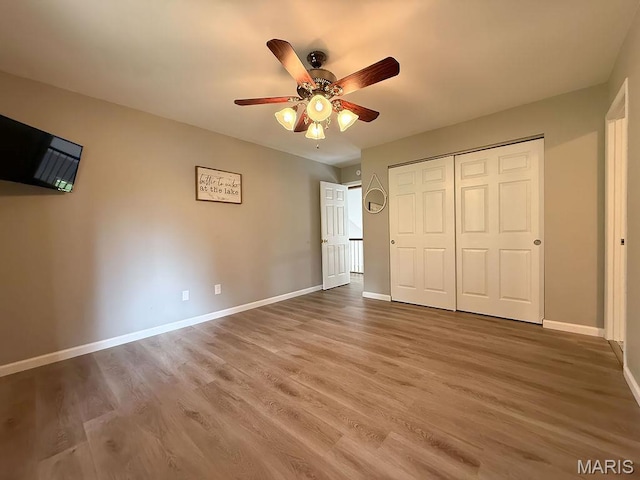 632 N Lafitte Dr, Bonne Terre, MO 63628 - unfurnished bedroom featuring wood finished floors, baseboards, a closet, and a ceiling fan