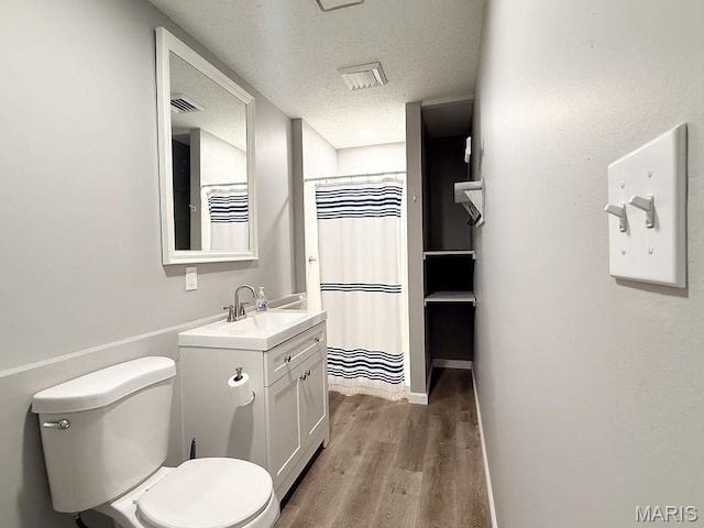 632 N Lafitte Dr, Bonne Terre, MO 63628 - bathroom with wood finished floors, toilet, vanity, a textured ceiling, and curtained shower