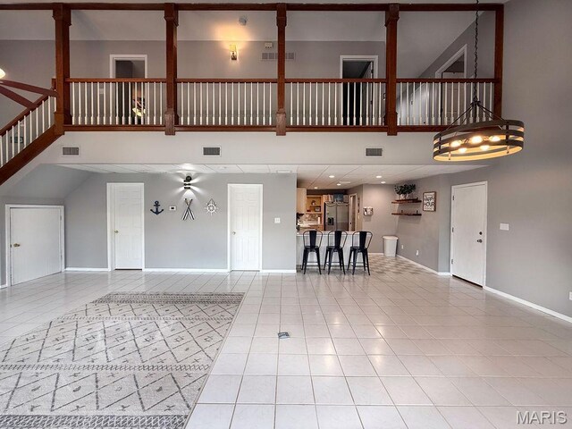 632 N Lafitte Dr, Bonne Terre, MO 63628 - unfurnished living room with a towering ceiling, light tile patterned floors, and baseboards