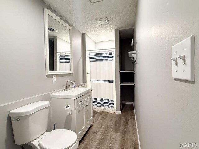 632 N Lafitte Dr, Bonne Terre, MO 63628 - bathroom with toilet, vanity, wood finished floors, a textured ceiling, and a shower with curtain