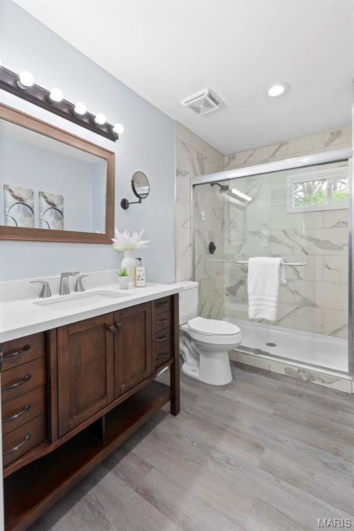 449 Hillcrest Blvd, Ballwin, MO 63021 - full bath featuring vanity, a marble finish shower, toilet, and wood finished floors