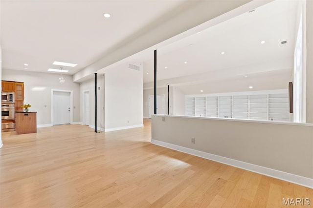 6 Brighton Way Unit 4D, Clayton, MO 63105 - unfurnished living room with light wood-style flooring, a skylight, and recessed lighting