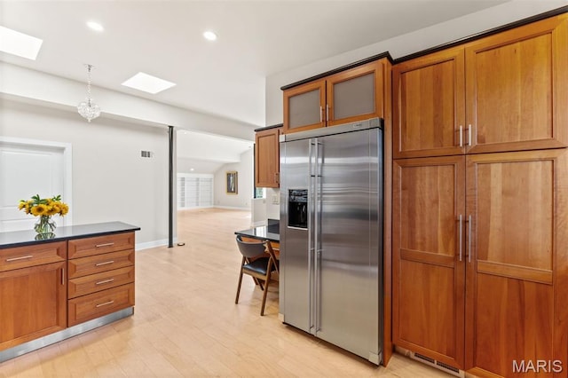 6 Brighton Way Unit 4D, Clayton, MO 63105 - kitchen with stainless steel built in refrigerator, a skylight, light wood finished floors, brown cabinetry, and recessed lighting